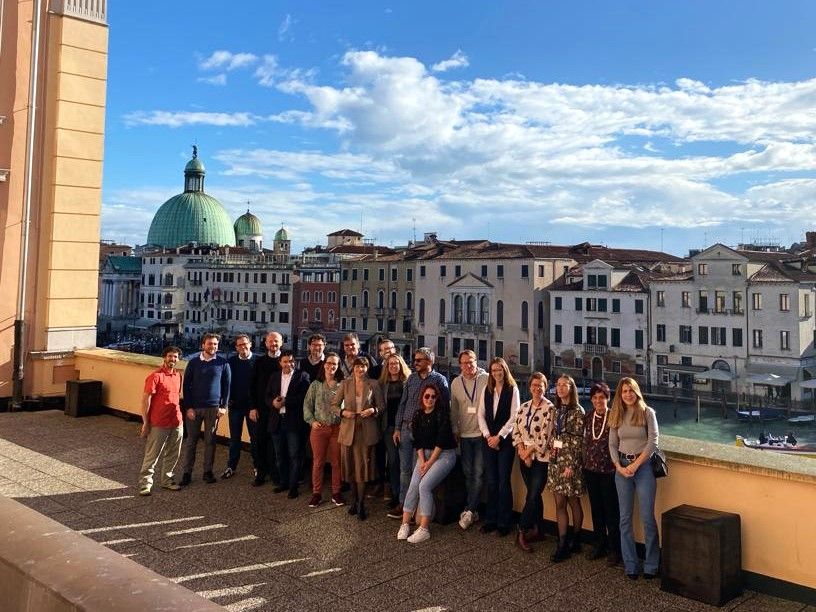 Gruppo di diciannove persone in posa per la foto su una terrazza con alle spalle il Canal Grande ed edifici veneziani